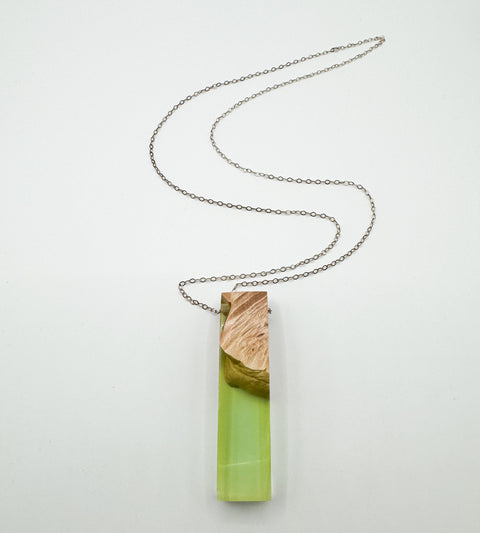 A sterling silver necklace with a large teardrop-shaped pendant made of wood and resin, displayed against a white background.
