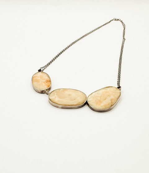 A sterling silver double chain with three stones necklace in a white background.