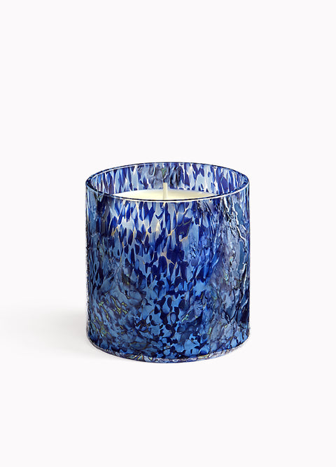 Blue marbled candle in a glass container on a white background