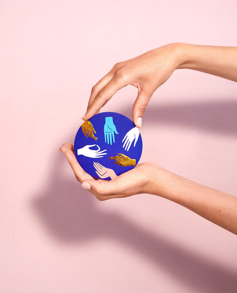 Hands holding a blue coaster.