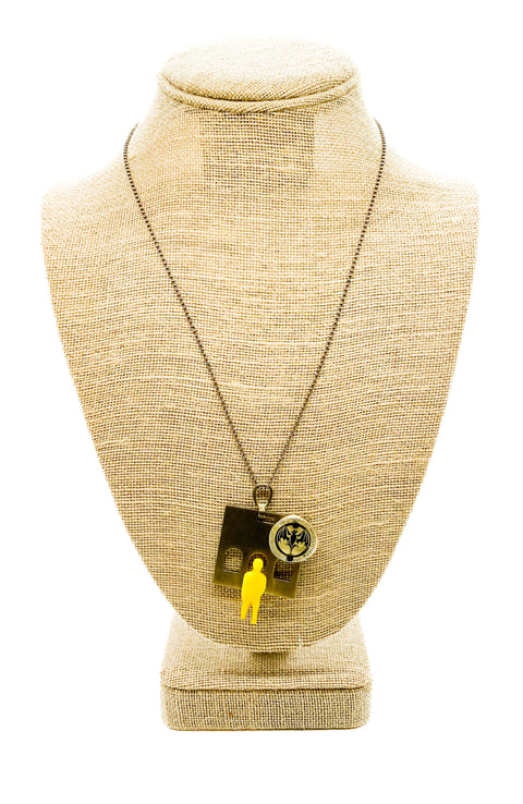 A necklace displayed on a mannequin necklace, featuring a black urchin clasp and stainless-steel links.