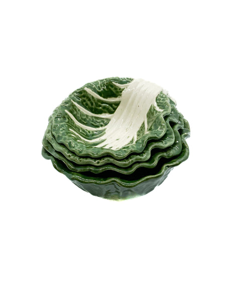 A set of four stoneware bowls in green color, with a leaf pattern resembling a cabbage shape, stacked inside each other.
