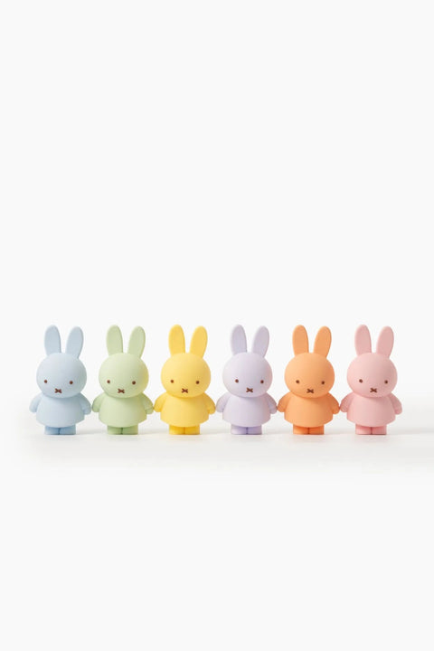 Five colorful rabbit figurines in a row on a white background