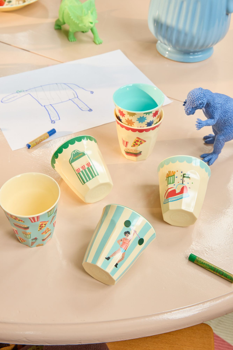 Colorful paper cups on a table with toys and coloring book