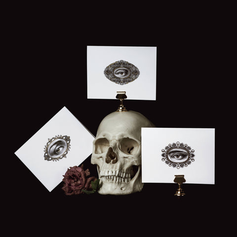 Skull with decorative eye designs on white cards against a black background