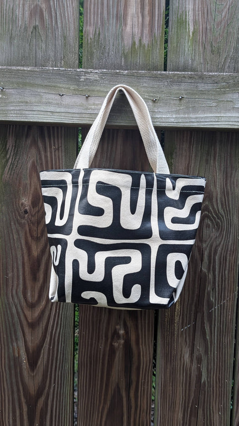 Black and white patterned bag hanging on a wooden fence