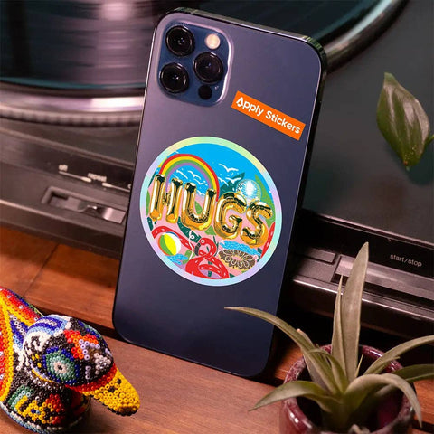 Phone case with 'HUGS' sticker on a table with decorative items
