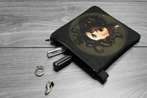 Black pouch with a Caravaggio replica on a wooden surface