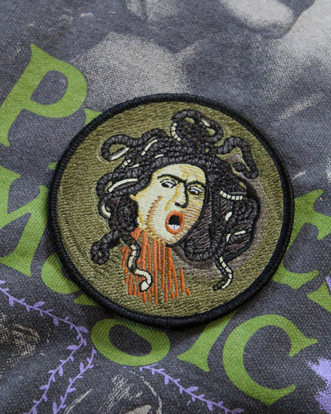 Embroidered patch of Medusa on a textured fabric background