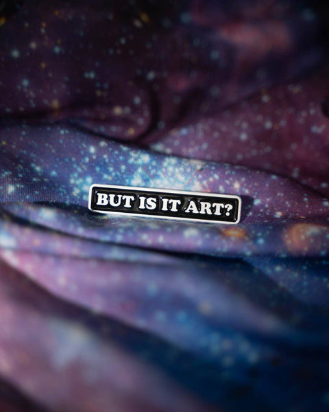 Star-patterned fabric with a 'But is it art?' pin