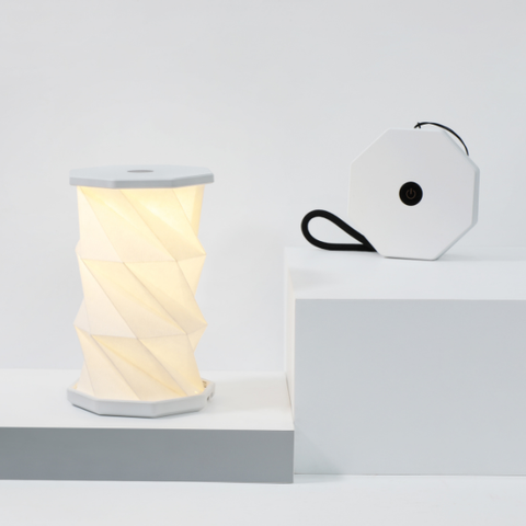 Spool-shaped lamp with a white box on a light gray background