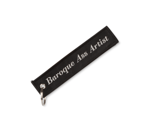 Black keychain with 'Baroque Ass Artist' text on a white background