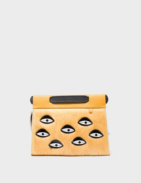 Yellow pouch with black eye designs on a light gray background