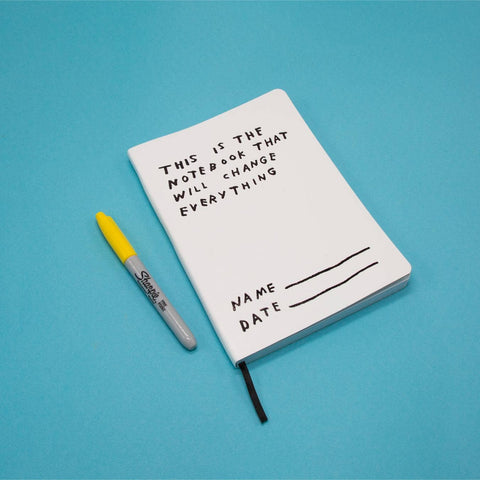 Notebook with text and a Sharpie pen on a blue background