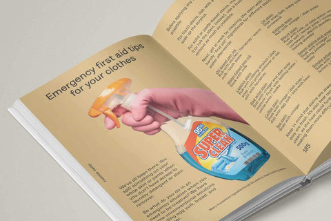 Open book with a page showing an illustration of a hand holding a bottle labeled 'Super Clean' and text about emergency first aid for your clothes tips.
