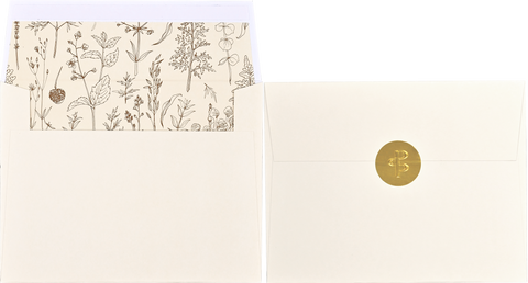 Stationery set with floral patterned paper and a gold-sealed envelope.