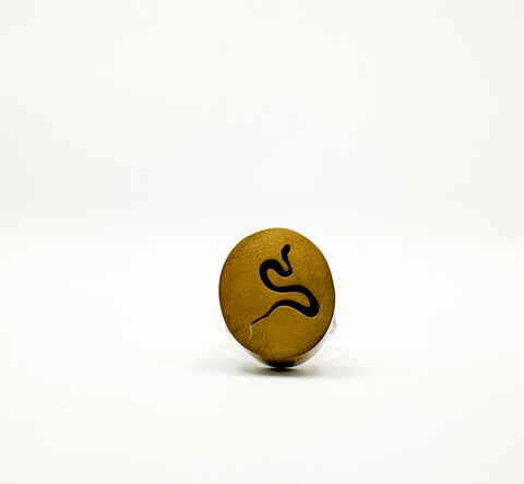 A gold-colored ring with a snake design on it, placed on a white background.