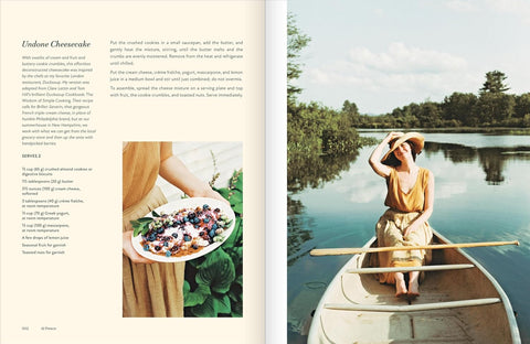 Book open to a page with a recipe on the left and a woman in a yellow dress rowing a boat on a lake on the right.