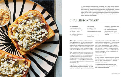 Toast with a cheese and herb topping on a black and white patterned plate, next to a recipe card for Charleston Toast.
