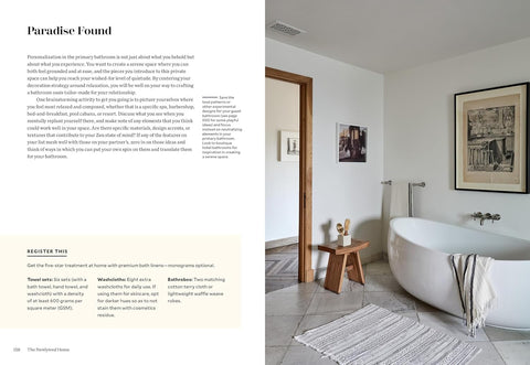 Bathroom interior with a freestanding bathtub, wooden stool, and framed pictures on the wall.