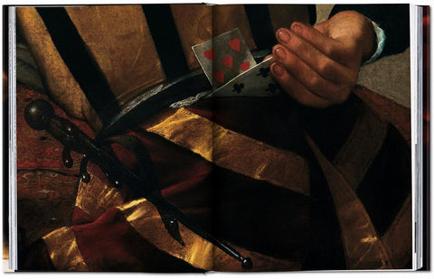 Close-up of a hand holding a playing card with a violin and fabric background