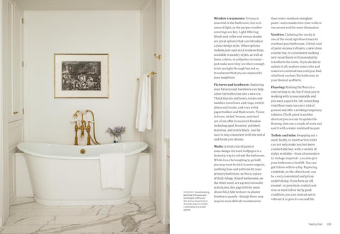 Bathroom with freestanding bathtub, towel, and framed picture on the wall.