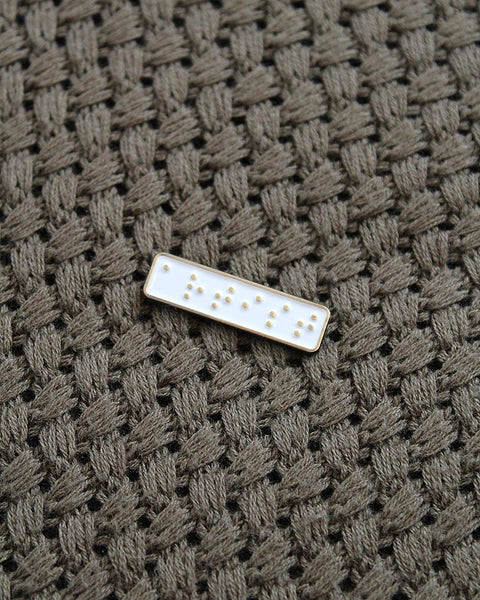 Rectangular shaped object with raised dots on a textured brown fabric background