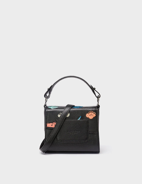 Black handbag with a strap on a light gray background
