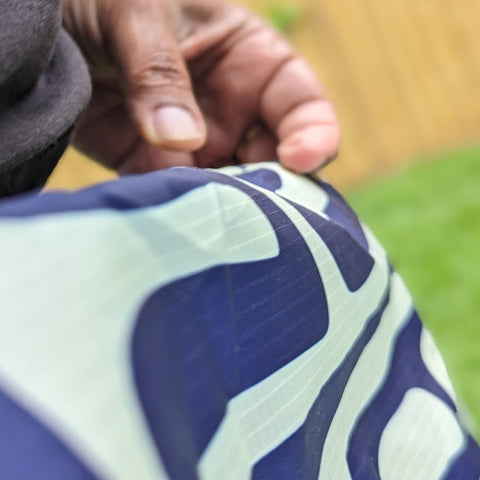 Close-up of a hand holding a patterned bag with a blurred background