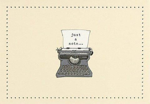 Vintage typewriter with a piece of paper reading 'just a note' on a beige background