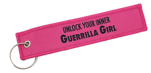 Pink keychain with 'Unlock Your Inner Guerrilla Girl' text on a white background