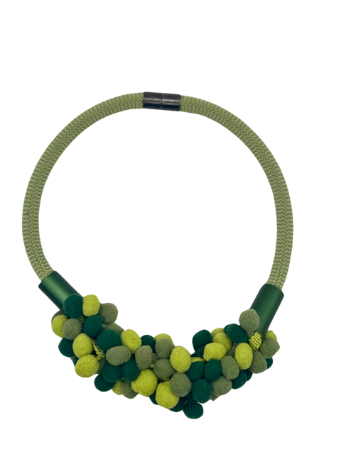 A green pom pom necklace with a variety of shades and tones, featuring a secure clasp