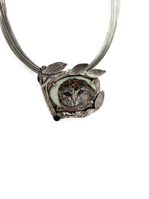 Silver owl pendant necklace on a white background