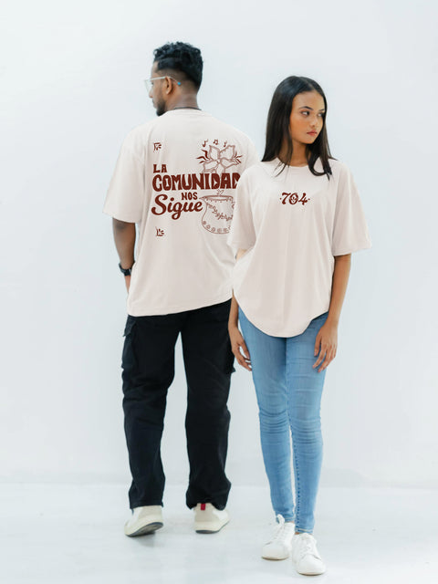 Two people wearing matching beige t-shirts with text on a white background