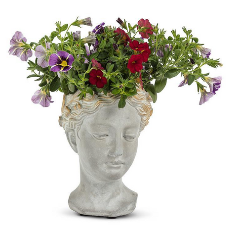 Flower arrangement on statue head with leafy hair on a white background