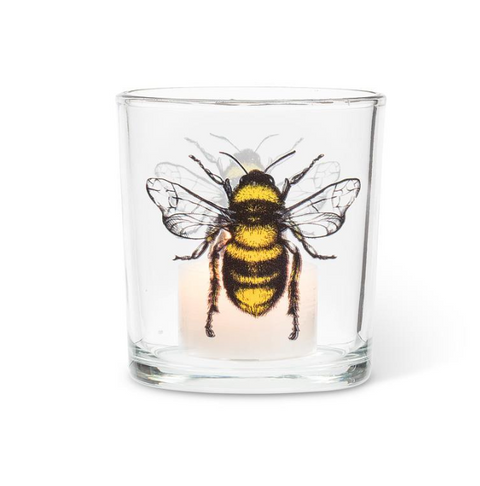 Clear glass candle holder with a bee design on a white background