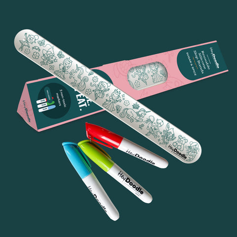 A bracelet and markers with decorative designs on a dark green background