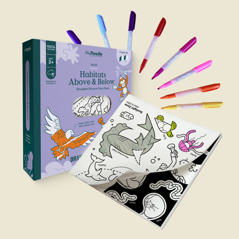 Coloring book titled 'Habitats Above & Below' with markers on a beige background