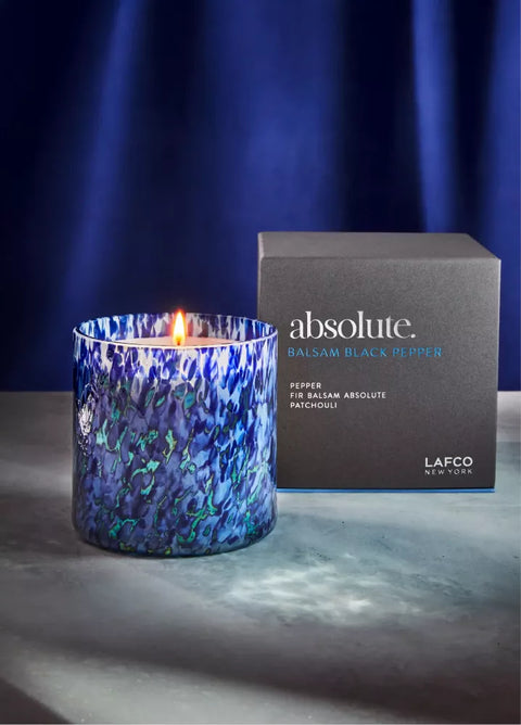 Blue marbled candle with 'absolute' packaging on a dark background