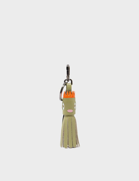 Green keychain with a cartoon face on a white background