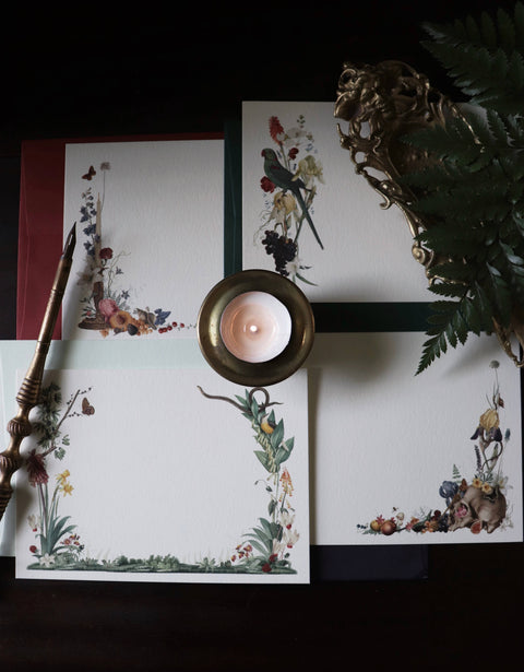 Decorative stationery items with floral designs on a dark surface.