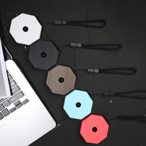 Hexagonal folded lamps in various colors on a dark surface with a laptop.