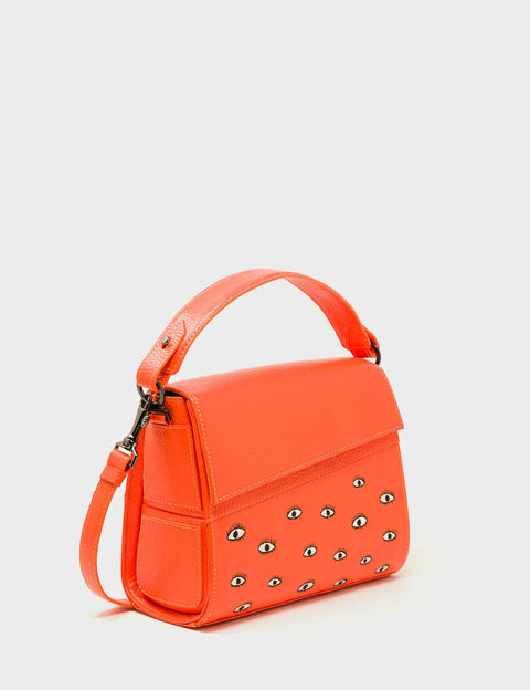 Orange handbag with decorative studs on a light gray background