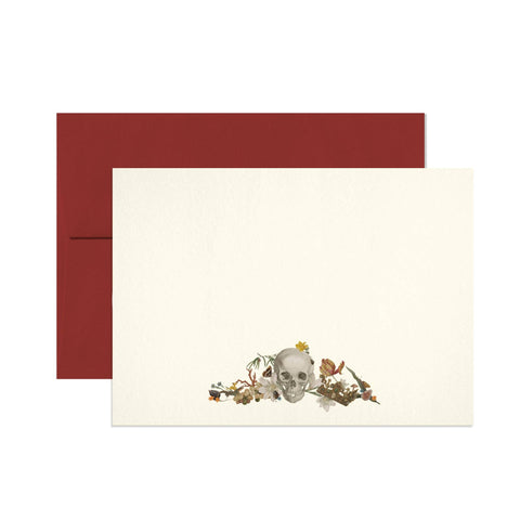 Card with skull and floral design on a white background, accompanied by a red envelope.