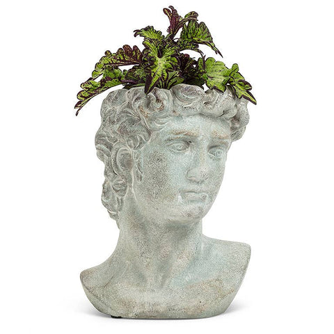 Stone bust of a classical figure with a plant on a white background
