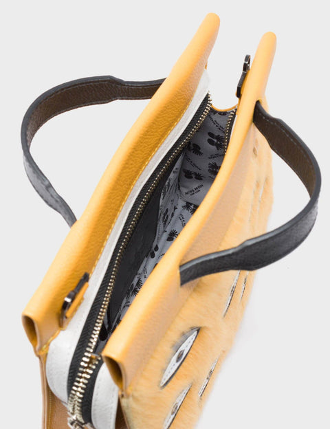 Yellow handbag with black interior on a light gray background