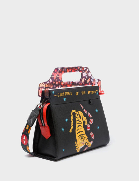 Black handbag with tiger design and colorful accents on a light gray background