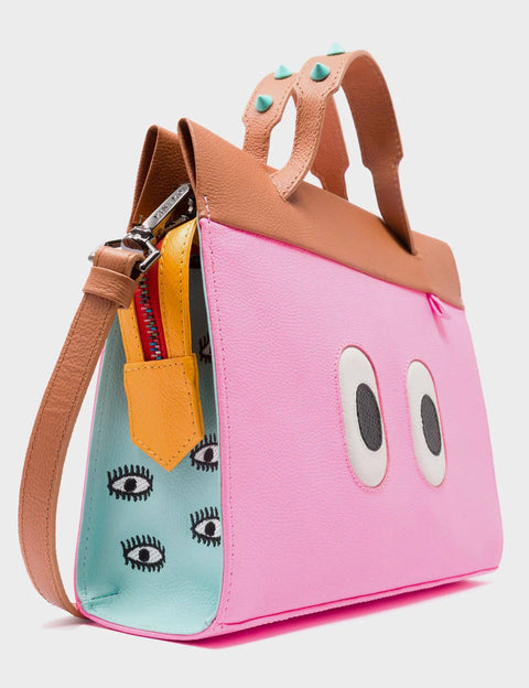 Pink bag with cartoon eye design and colorful interior on a light gray background