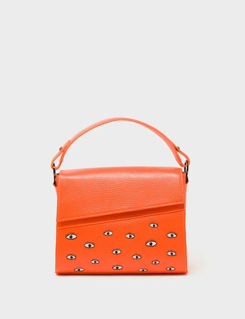 Orange handbag with eyes pattern on a light gray background