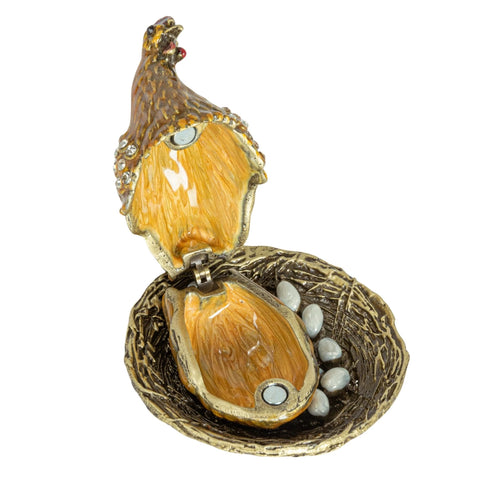 Open enameled metal hen trinket box in a white background 
